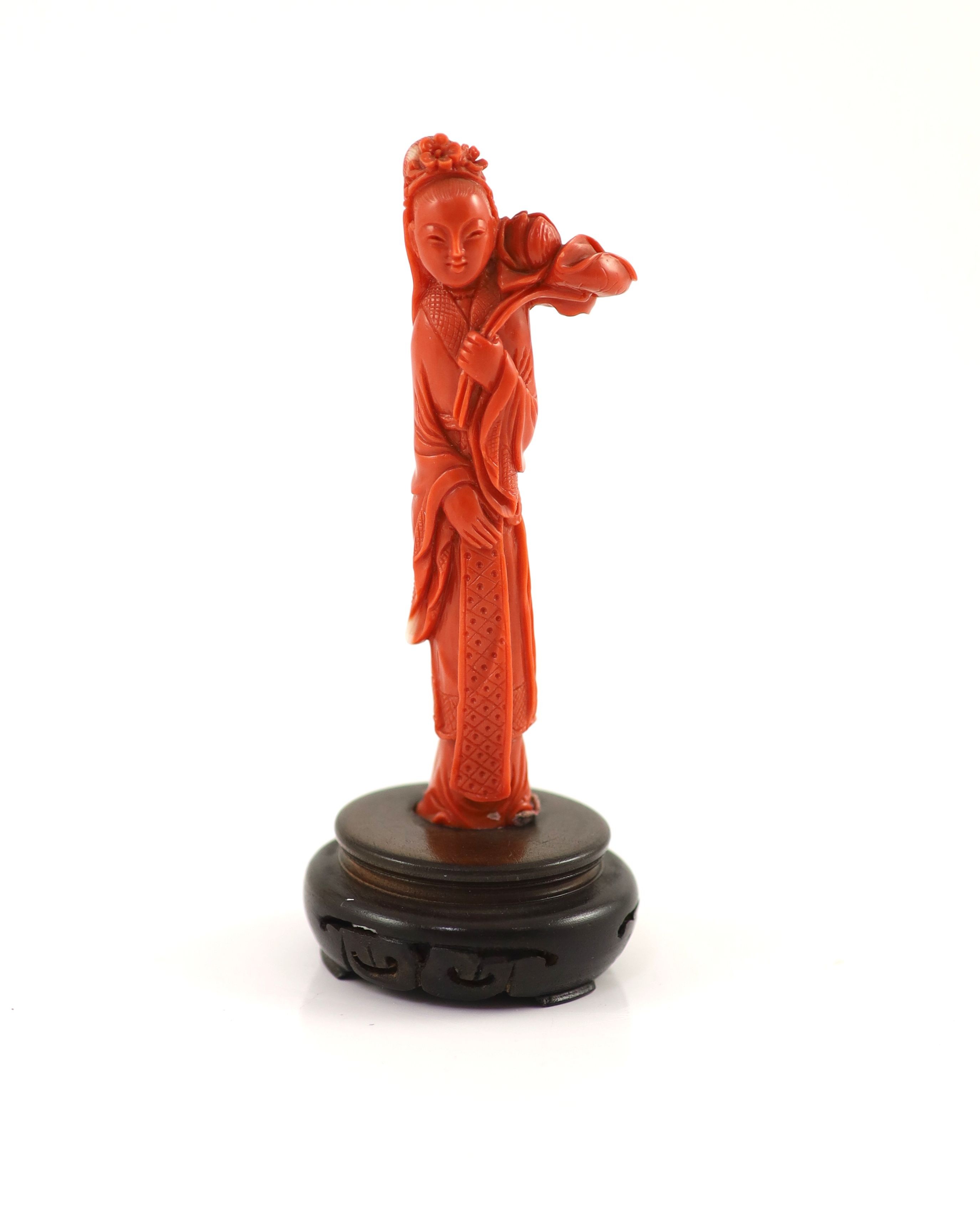 A Chinese coral figure of a tall lady holding a Lotus sprig, mid 20th century 11.1 cm high, 59g, wood stand